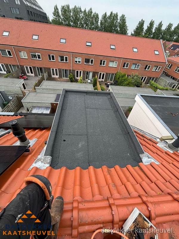 Bitumen dak reparatie op plat dak tussen dakpannen in Kaatsheuvel
