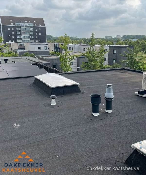 Groot plat dak met lichtkoepel en dakdoorvoeren in Kaatsheuvel
