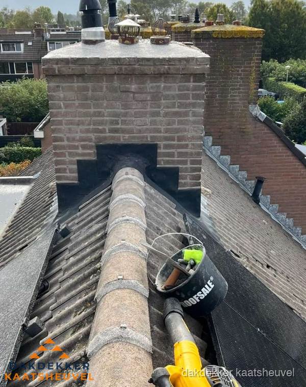Schoorsteen met loodaansluiting en nokvorst op pannendak in Kaatsheuvel
