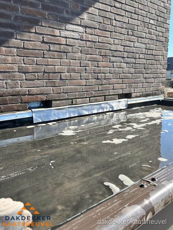 Stilstaand water op plat dak door slechte afwatering in Kaatsheuvel