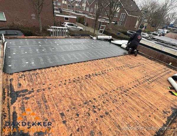 Dakdekker legt onderlaag op plat dak met houten constructie in Kaatsheuvel