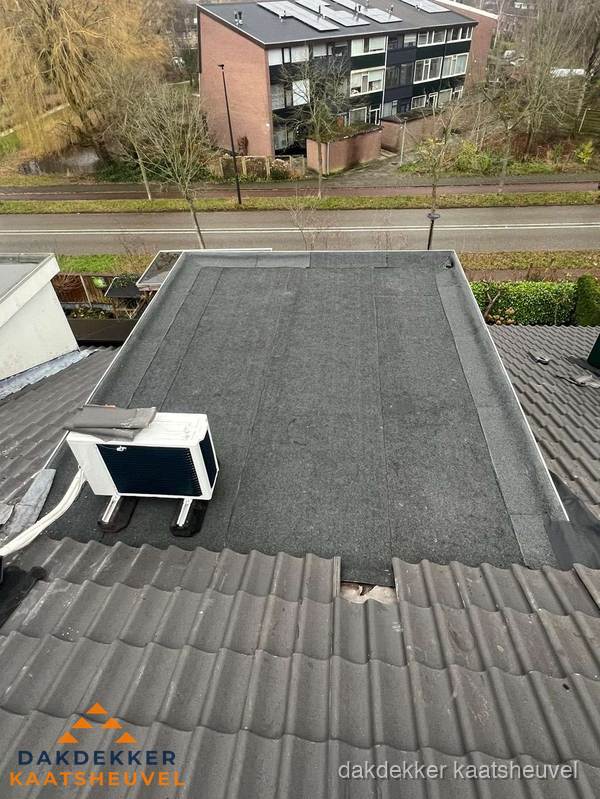 Plat dak inspectie met bitumen bedekking naast schuin pannendak in Kaatsheuvel