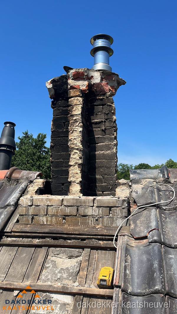 Beschadigde schoorsteen met nieuwe rookgasafvoer op oud dak in Kaatsheuvel