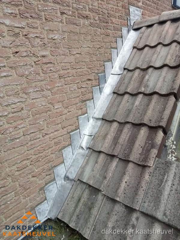 Loodslabben langs dakaansluiting bij bakstenen muur in Kaatsheuvel