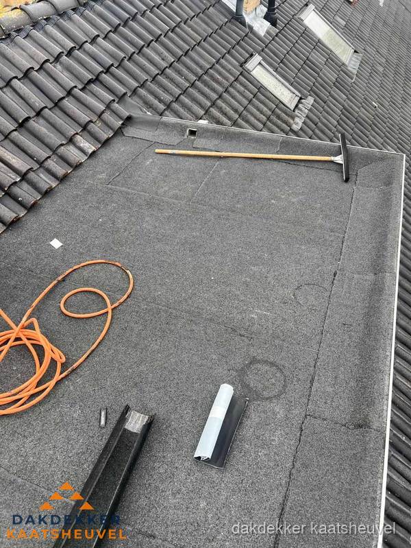 Plat dak reparatie met gereedschap en loodstroken in Kaatsheuvel