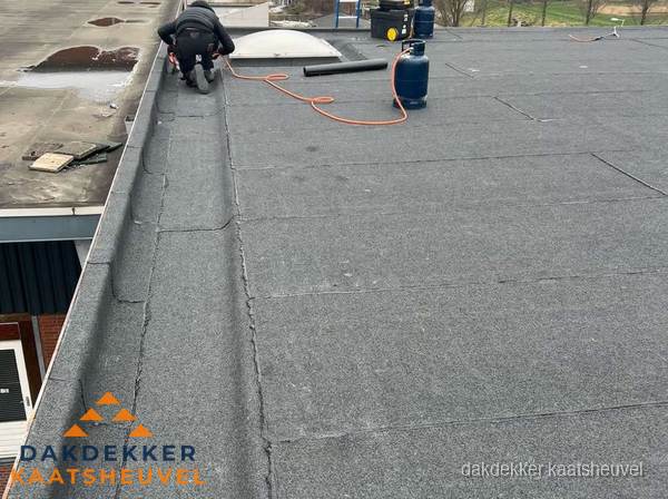 Dakdekker repareert bitumen dakbedekking op groot plat dak in Kaatsheuvel Dakdekker repareert bitumen dakbedekking op groot plat dak in Kaatsheuvel